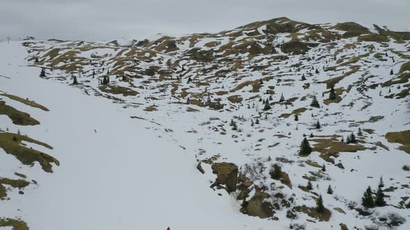 Aerial, Winter Landscape In Dolomites Mountains And Skiers On Ski Tracks On A Cloudy Day In Italy