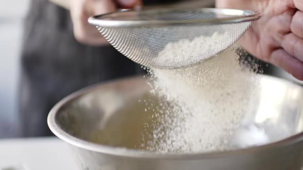 Woman Sifting Flour in a Bowl alt
