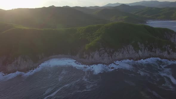 Aerial View of the Beautiful Sea Coast with Clear Blue Water at Sunset alt