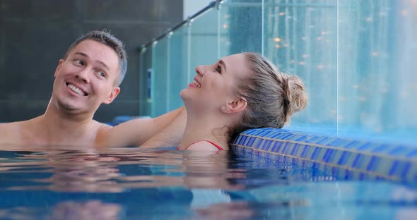 Joyful Couple Communicates in Swimming Pool Water Closeup