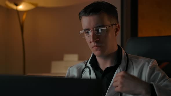 Caucasian Male Doctor Portrait with Stethoscope Behind Laptop alt