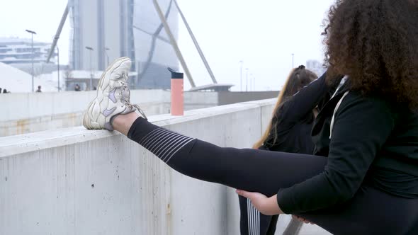 Sporty young women stretching on bridge alt