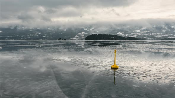 Yellow Special Mark Buoy On Frozen Steinsfjorden Lake With Clouds In Norway. - timelapse alt