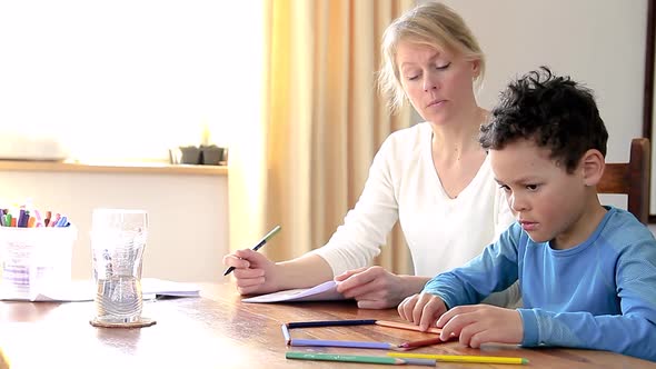 homework at home with mother and child doing homework on the table with pen and paper stock footage alt