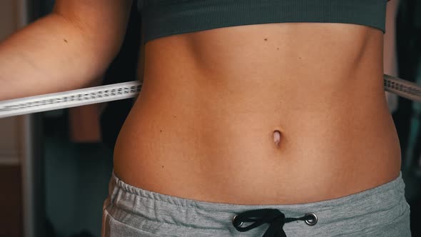 Girl With a Beautiful Figure Measures Her Waist with a Measuring Tape alt