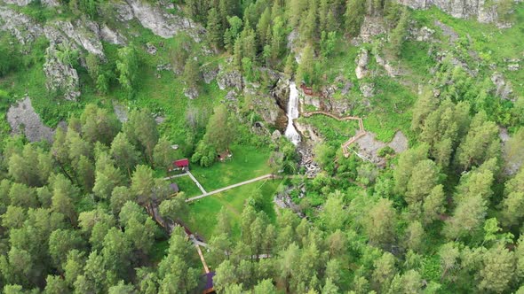 Drone Flying Over a Green Forest with Waterfall in the Altai Mountains