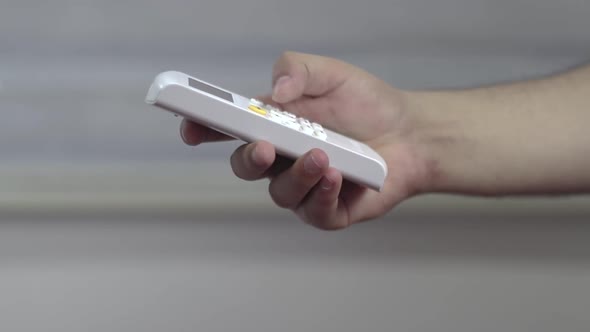 Man Press Buttons And Turning On Air Conditioner With Remote Control alt
