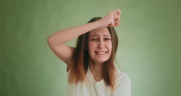 Angry Sad Young Woman Shakes Hands and Jumps on Green alt