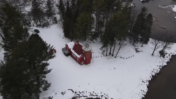4k drone video of Sandpoint Lighthouse in Baraga, Michigan in the winter. alt