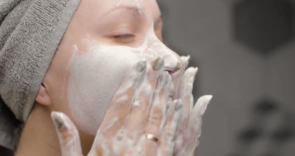 Beautiful Woman Enjoying the Process of Cleansing Her Face with Facial Wash with Closed Eyes