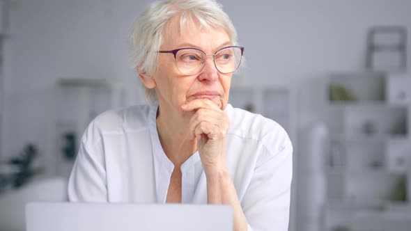 Thoughtful old businesswoman with short grey hair alt