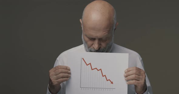 Worried businessman holding a negative financial chart