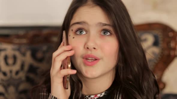 Teen Girl is Worried Talking on a Smartphone alt