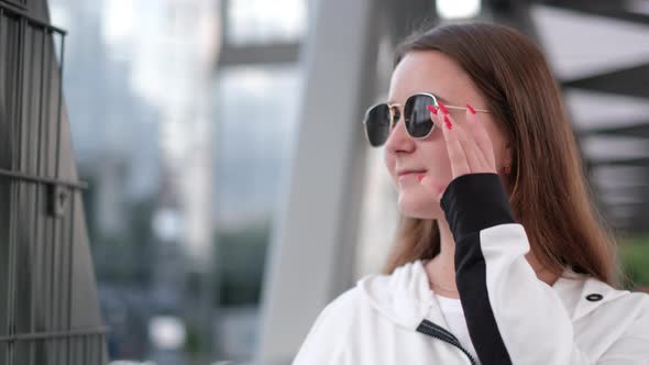 Brunette Girl in Sunglasses She Looks at the Camera and Laughs alt