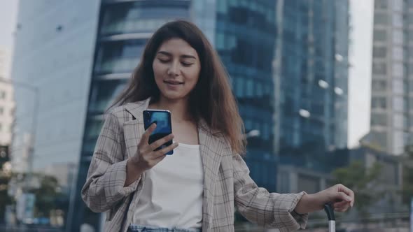 Girl Walking Down the Street with Suitcase and Calling About Working Matters alt
