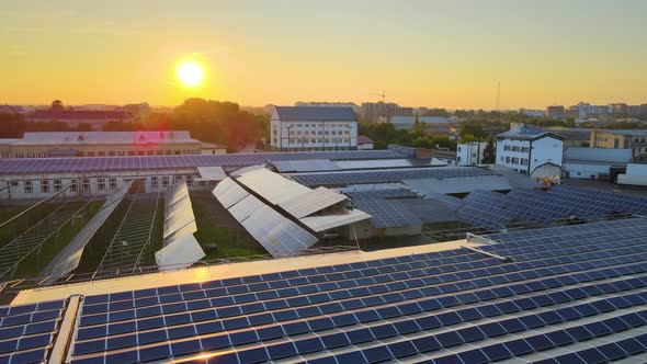 Aerial View of Solar Power Plant with Blue Photovoltaic Panels Mounted on Industrial Building Roof alt