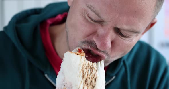 Young Man Eating Delicious Appetizing Shawarma  Movie alt