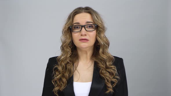 Bussines Female Stands Worrying in Expectation and Then Smiles with Relief at Grey Background alt