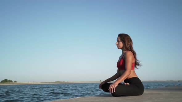 Young athletic Caucasian girl practices yoga Sits in a lotus position on pantone alt