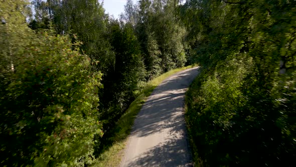 Old road snaking up forested mountainside; first person view alt