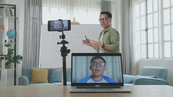 Asian Male Teacher Teaching Math On With Boy Student In On Laptop Screen At Home alt