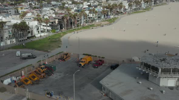 AERIAL Flight Over Beach with Volleyball Nets at Venice Beach with Palm Trees and Bike Lane Sunny alt