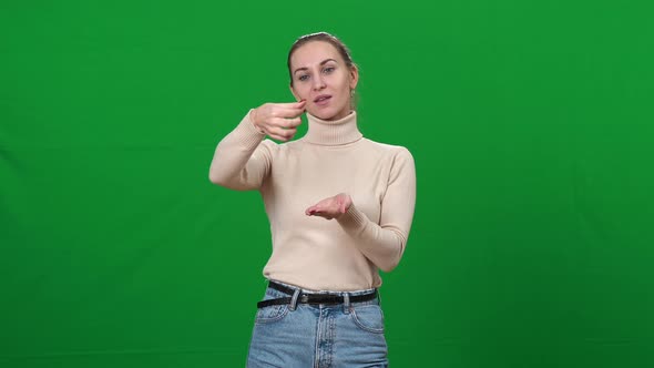 Positive Woman Imitating Virtual Cosmetics Testing on Green Screen alt