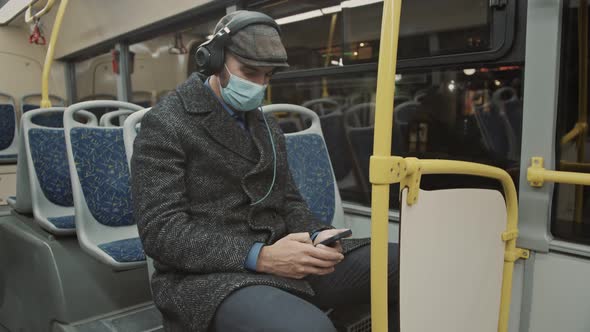 4k video footage of a young man using a smartphone and headphones while traveling on a bus. alt