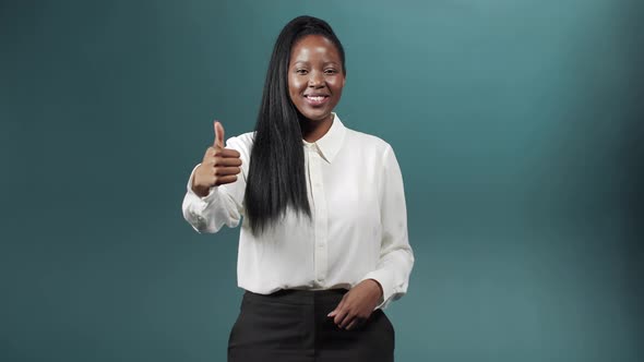 A Jolly African Woman is Showing a Thumb Up and Smiling alt