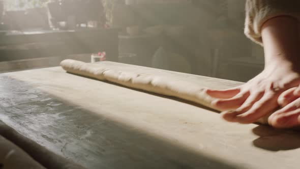 Piece of Raw Clay Is Being Rolled Out By Woman alt