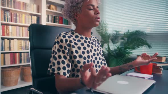 Calm African American Woman with Closed Eyes Meditating at Workplace alt