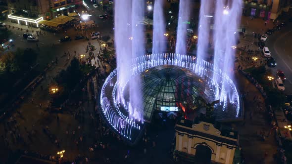 Aerial View of People Walking Around of Colorful Fountain on the Square alt