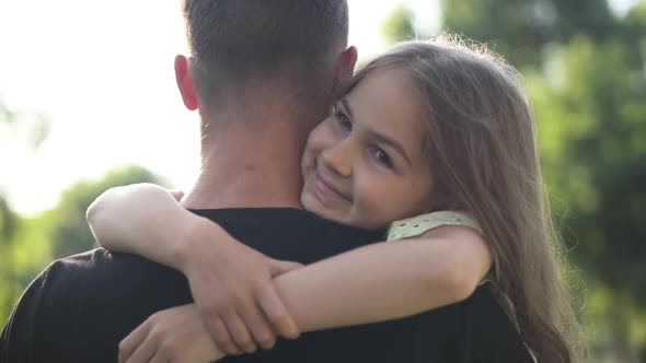 Portrait of Happy Girl Hugging Man Outdoors in Summer Spring Park Looking Away alt