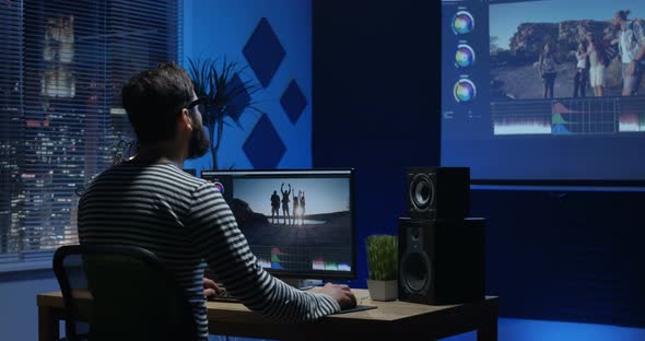 Young Man Sitting Back and Editing Video Inside a Room alt