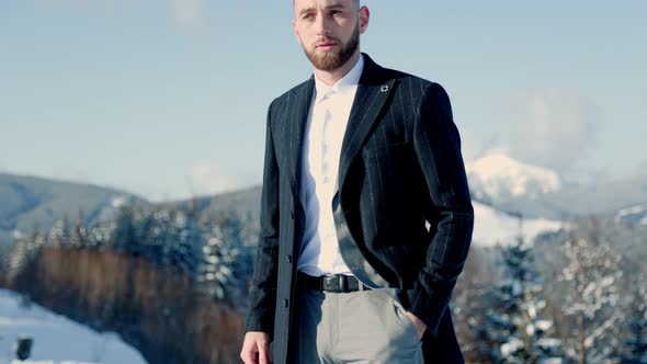 Groom on the Background of Snowcapped Mountains alt