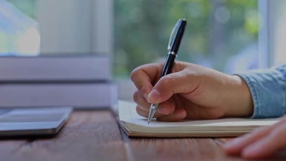 a business woman writing a letter on a notebook