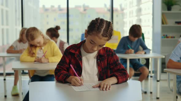 Beautiful Longhaired Brunette Asian Pupil Wearing Glasses Sits at a First Desk in the Classroom and alt