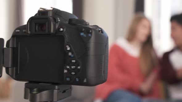 Young video bloggers having fun together and creating content while making a video at home alt