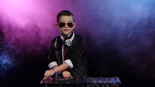 Stylish Boy Dj with Glasses Playing on Vinyl. Smoky Background alt
