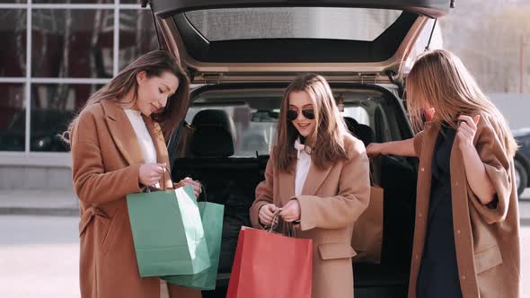 Attractive Girls Have Shopped and Checking Purchases at the Car Back alt