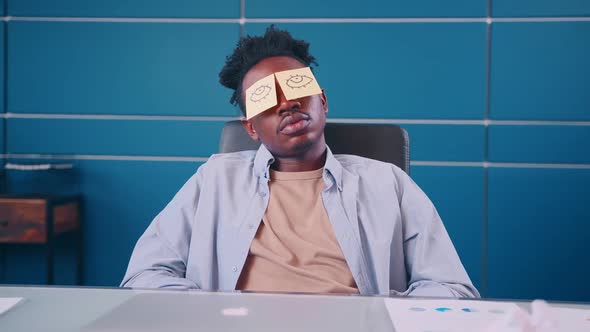 Funny Exhausted Man Sleeping at Workplace Withdrawn Eyes on Sticky Notes on Face alt
