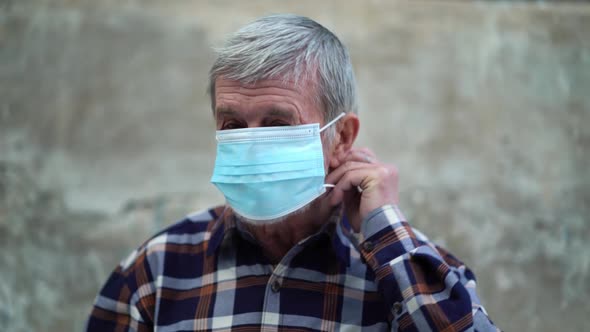 An Old Man Is Using Face Mask for Protect From Virus Against the Second Wave Quarantine Coronavirus alt