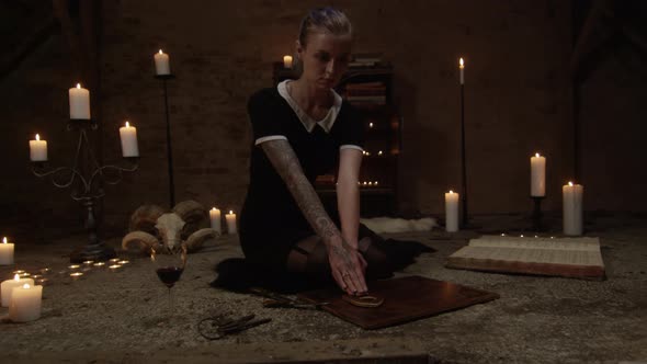 Frightened Woman Using Ouija Board In Candle Lit Attic alt