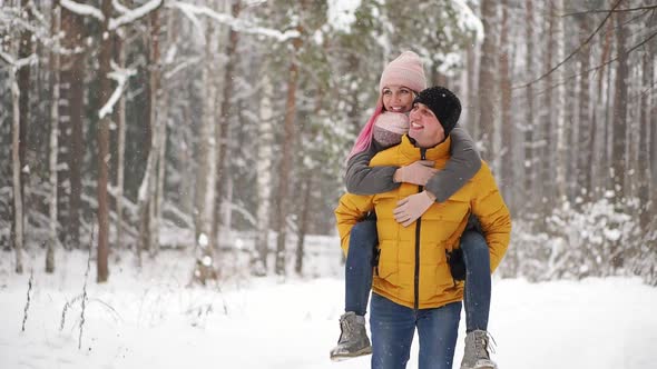 Happy Loving Couple Walking in Snowy Winter Forest, Spending Christmas Vacation Together. Outdoor alt