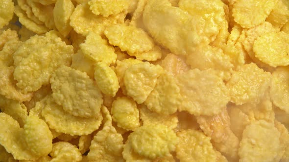 Crispy hot corn flakes rotating with smoke close up, dry healthy breakfast. Honey cornflakes alt