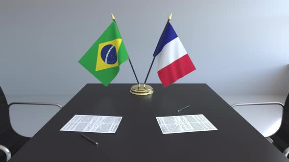Flags of Brazil and France and Papers on the Table alt