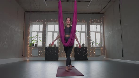 Aerial Yoga  a Young Woman Walks to the Hammock and Smiles alt