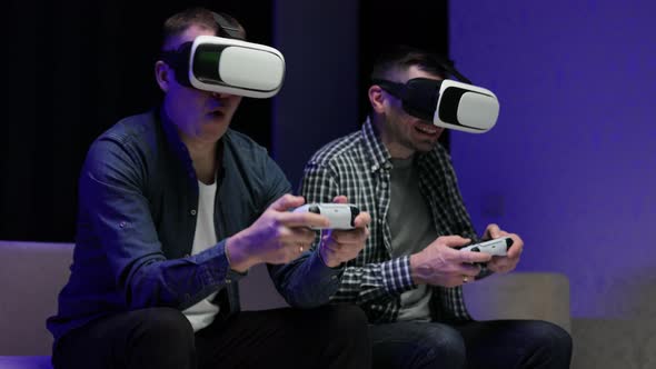 Excited Funny Young Gamers Wear Virtual Reality Glasses Holding Controllers Playing Video Game