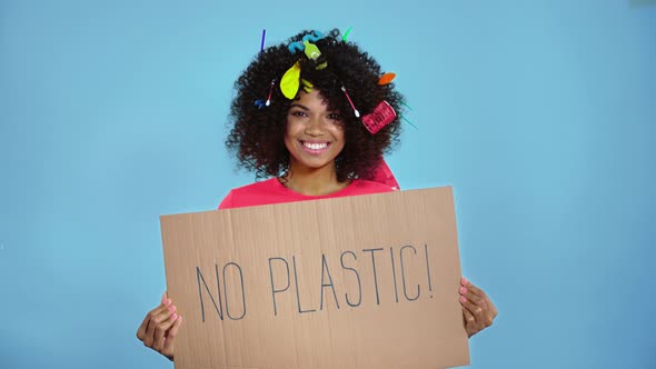 Woman holding placard with inscription no plastic.