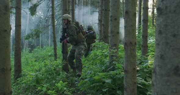 Millitary Operation with Gorup of Soliders Attacking Enemy Line in Dense Forest During Day Time